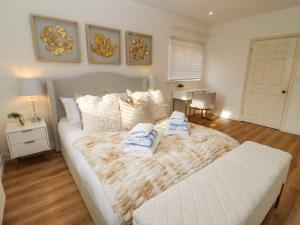 a bedroom with a bed with two towels on it at Snowdrop in Blandford Forum