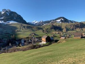uma aldeia numa colina com montanhas ao fundo em Haus Stelz em Nesslau