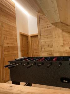 uma mesa de pingue-pongue num quarto com paredes de madeira em Haus Stelz em Nesslau