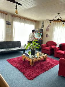a man playing a video game in a living room at Purple Fox in Ancud