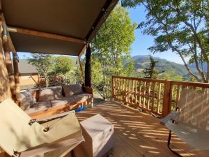um alpendre com um sofá e uma mesa num deque em Camping Villaggio Il Collaccio em Preci