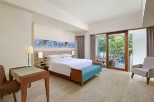努沙杜瓦的住宿－巴厘島努沙杜瓦萬怡度假酒店，酒店客房配有一张床、一张桌子和一把椅子。