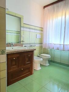 a bathroom with a sink and a toilet and a mirror at Marinaway - Appartamenti a 2 chilometri dal mare in Orosei