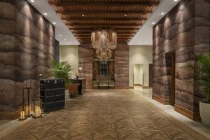 a lobby of a hotel with a stone wall at The Ben, Autograph Collection in West Palm Beach