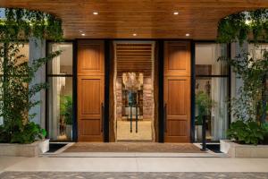 una entrada a un edificio con puertas de madera en The Ben, Autograph Collection en West Palm Beach