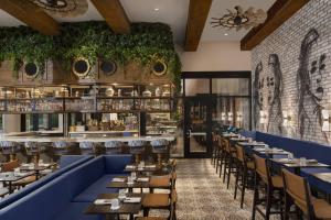 a dining room with blue tables and chairs at The Ben, Autograph Collection in West Palm Beach