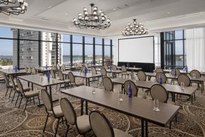 a conference room with tables and chairs and a projection screen at The Ben, Autograph Collection in West Palm Beach