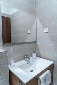 bagno con lavandino e specchio di Rózsa Étterem & Panzió a Pécs