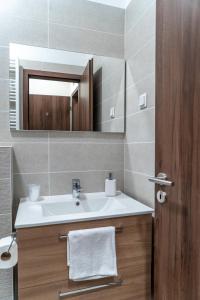 uma casa de banho com um lavatório e um espelho em Rózsa Étterem & Panzió em Pécs