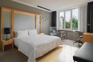a bedroom with a bed and a desk and a chair at Le Méridien Hamburg in Hamburg
