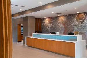 a lobby with a reception desk and a brick wall at SpringHill Suites by Marriott Cape Canaveral Cocoa Beach in Cape Canaveral