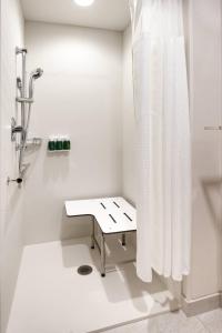 Fairfield Inn & Suites by Marriott Virgin Zion National Park في العذراء: حمام أبيض مع دش ومقعد