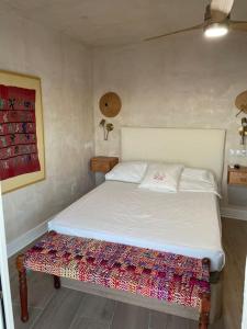 Un dormitorio con una cama blanca con una manta de colores. en Maravilloso apartamento en primera línea de playa., en Torreguadiaro