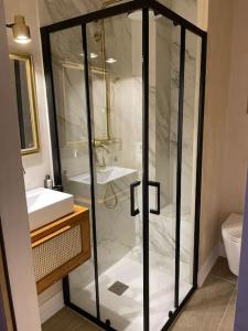 uma casa de banho com uma cabina de duche em vidro e um lavatório. em Maravilloso apartamento en primera línea de playa. em Torreguadiaro