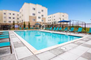 a pool with chairs and umbrellas at a hotel at Fairfield Inn & Suites by Marriott San Jose North/Silicon Valley in San Jose