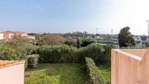 a view of a yard with bushes and a fence at Port Lano- 172- Appart bonne exposition- 4 pers in Cap d'Agde