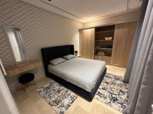 Un dormitorio pequeño con una cama y un espejo. en MODERNE, LUXUEUX et FRONT DE MER, en Tánger