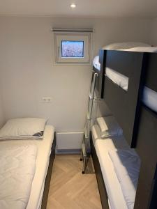 a small room with two bunk beds and a window at Vogelvrij, vakantie woning met landelijk uitzicht en geheel omheinde tuin in Burgerbrug