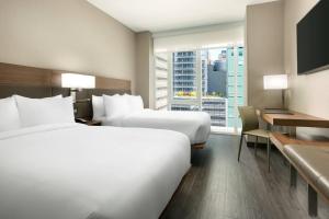 2 letti in una camera d'albergo con finestra di AC Hotel by Marriott New York Times Square a New York