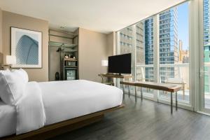 a bedroom with a white bed and a large window at AC Hotel by Marriott New York Times Square in New York