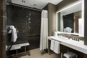 a bathroom with a shower and a sink and a mirror at AC Hotel by Marriott New York Times Square in New York