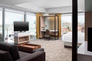 um quarto de hotel com uma televisão, uma cama e uma secretária em SpringHill Suites by Marriott Greenville Downtown em Greenville