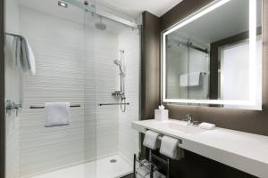 a bathroom with a shower and a sink and a mirror at AC Hotel by Marriott New York Times Square in New York