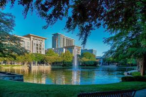 uma fonte num lago numa cidade com edifícios em Dallas/Plano Marriott at Legacy Town Center em Plano