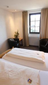 een hotelkamer met 2 bedden en een raam bij Hotel Burg Breuberg in Höchst im Odenwald