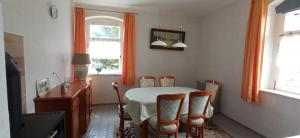 a dining room with a table and chairs and a window at OK FERIEN - Altes Bahnhaus in Muldenhammer