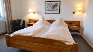 a bedroom with a large bed with white pillows at Hotel Burg Breuberg in Höchst im Odenwald