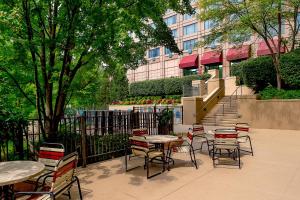 un patio con mesas y sillas frente a un edificio en Marriott St. Louis West, en Chesterfield