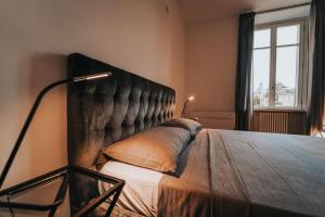 ein Schlafzimmer mit einem großen Bett mit einem großen Kopfteil in der Unterkunft Appartamento esclusivo fronte lago, in centro a Como con garage in Como