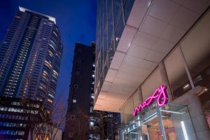 a neon sign on the side of a building at MOXY Osaka Honmachi by Marriott in Osaka