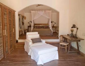 a bedroom with a bed and a table and chairs at Casa Angatu in Trancoso