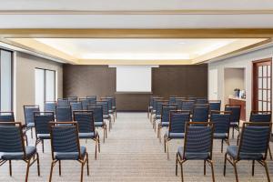 a room with rows of chairs and a projection screen at Courtyard Houston Sugar Land/Stafford in Stafford