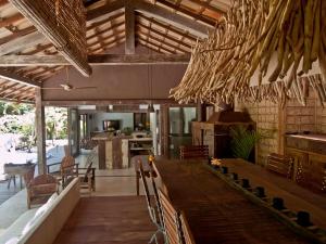 a dining room with a bar and a kitchen at Casa Angatu in Trancoso