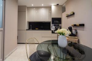 a glass table with chairs and a vase of flowers at MAISON GAMBETTA in Deauville +8 photos