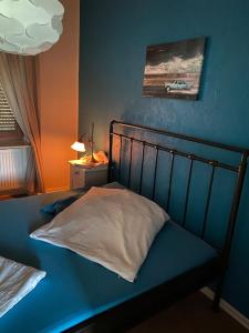 ein Schlafzimmer mit einem blauen Bett und einem weißen Kissen in der Unterkunft Apartment mit romantischem Garten an der Märchenstraße! in Reinhardshagen