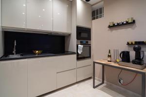 a kitchen with white cabinets and a counter with a sink at MAISON GAMBETTA in Deauville