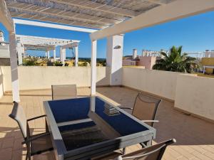 d'une terrasse sur le toit avec une table et des chaises. dans l'établissement Terraços Vista Mar Royal Cabanas, à Cabanas de Tavira