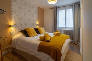 a bedroom with a bed with two stuffed animals on it at MAISON GAMBETTA in Deauville