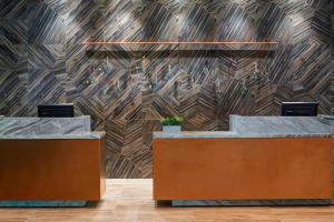 um átrio com duas mesas de recepção e uma parede de madeira em Chicago Marriott Southwest at Burr Ridge em Burr Ridge