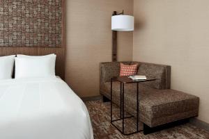 a hotel room with a bed and a chair at Chicago Marriott Southwest at Burr Ridge in Burr Ridge