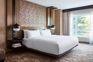 una camera da letto con un grande letto bianco e una finestra di Chicago Marriott Southwest at Burr Ridge a Burr Ridge