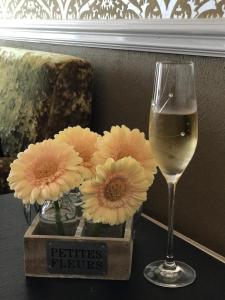 un bicchiere di vino accanto a un vaso di fiori di Atlanta a Eastbourne