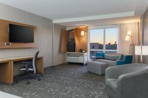 a hotel room with a desk and a television at Courtyard by Marriott Dallas Midlothian at Midlothian Conference Center in Midlothian