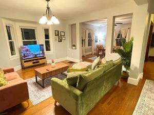 uma sala de estar com um sofá verde e uma televisão em #23 ROOM IN THE HOUSE Newton-Wellesley Hospital 5 min walk away em Newton