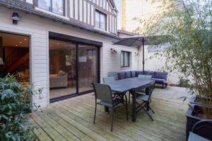 a patio with a table and chairs on a deck at MAISON GAMBETTA in Deauville