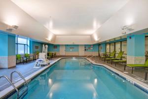 a swimming pool with chairs and tables in a building at SpringHill Suites by Marriott Cincinnati Midtown in Cincinnati